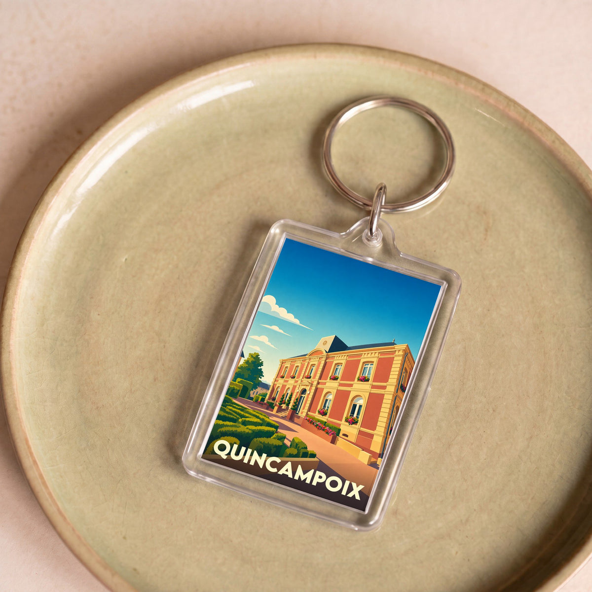 Porte-clés souvenir de la ville de Quincampoix avec une illustration stylisée.
