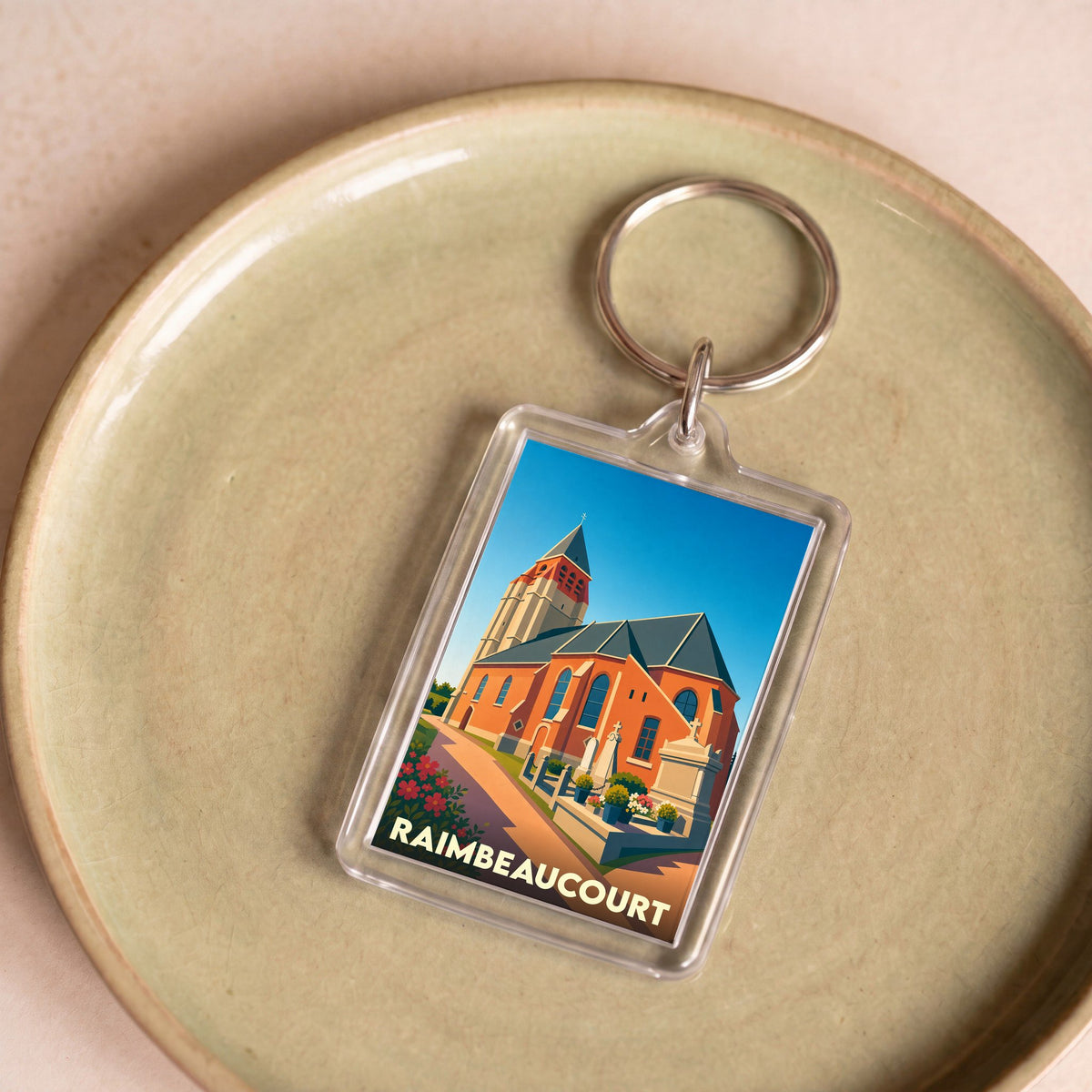 Porte-clés souvenir de la ville de Raimbeaucourt avec une illustration stylisée de son église.
