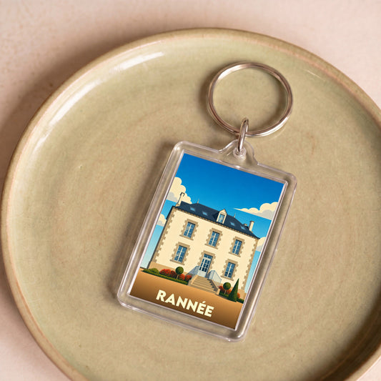 Porte-clés souvenir de la ville de Rannée avec une illustration stylisée d'une maison bourgeoise.