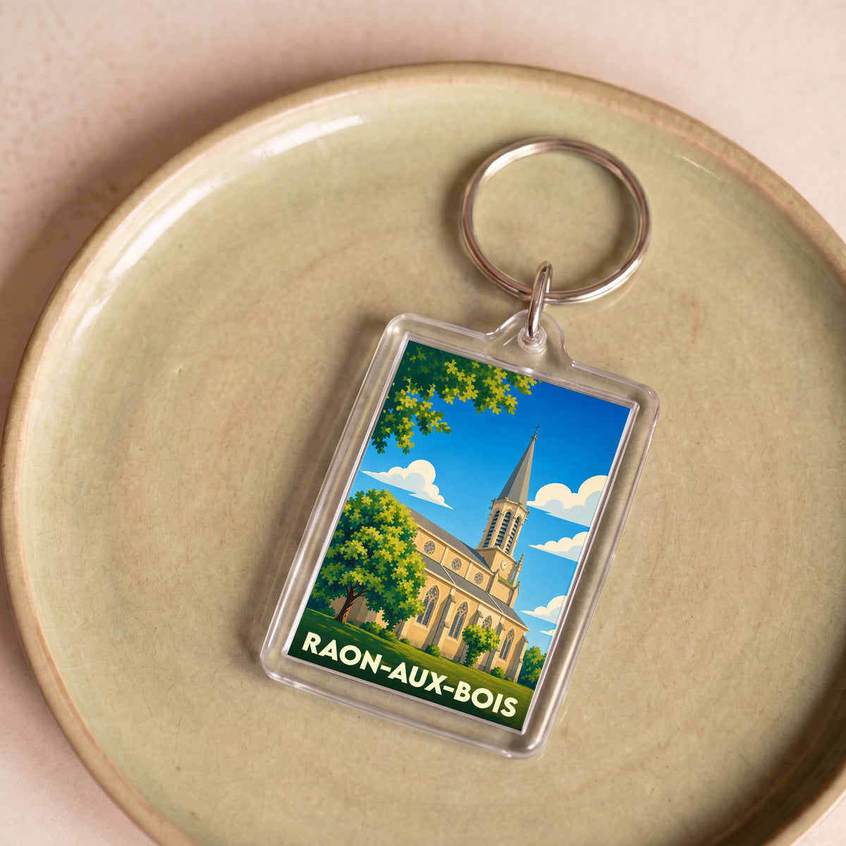Porte-clés souvenir de la ville de Raon-aux-Bois avec une illustration stylisée de son église.