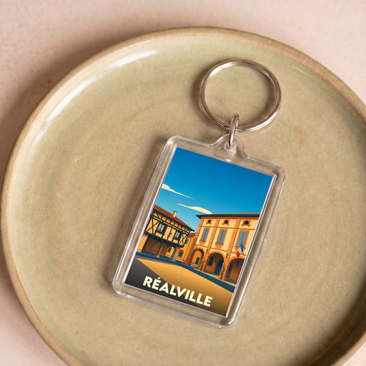 Porte-clés souvenir de la ville de Réalville avec une illustration stylisée.
