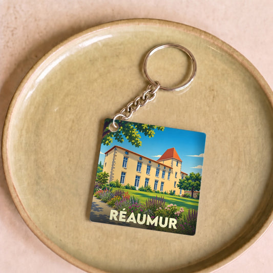 Porte-clés souvenir de la ville de Réaumur avec une illustration stylisée d'un manoir.