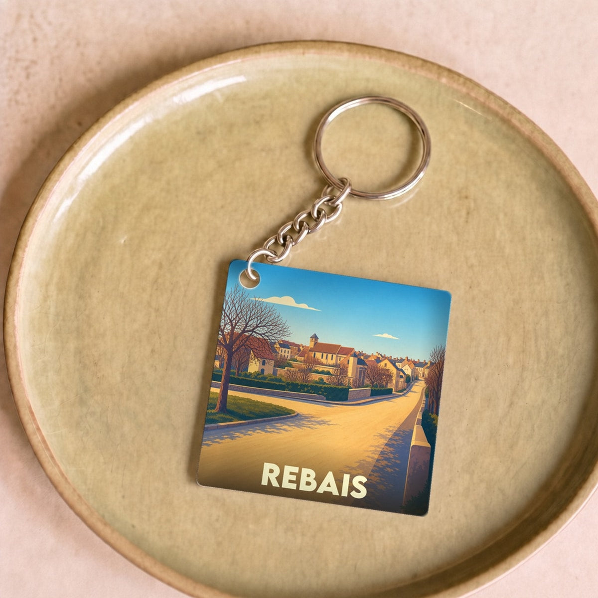 Porte-clés souvenir de la ville de Rebais avec une illustration stylisée.