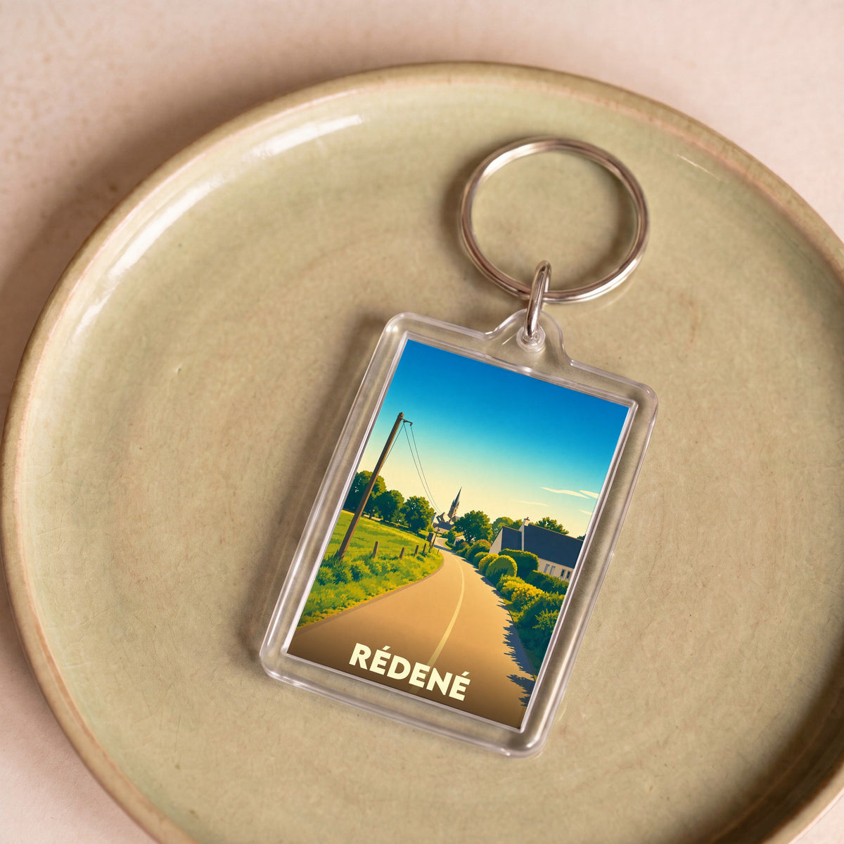 Porte-clés souvenir de la ville de Rédené avec une illustration stylisée.