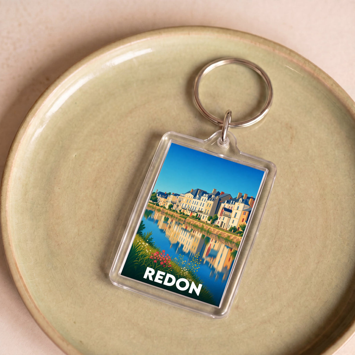 Porte-clés souvenir de la ville de Redon avec une illustration stylisée des bords de la Vilaine.
