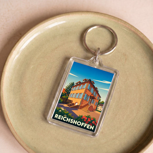 Porte-clés souvenir de la ville de Reichshoffen avec une illustration stylisée d'un bâtiment historique.