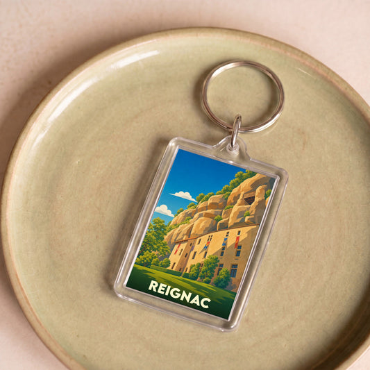 Porte-clés souvenir de la ville de Reignac avec une illustration stylisée.