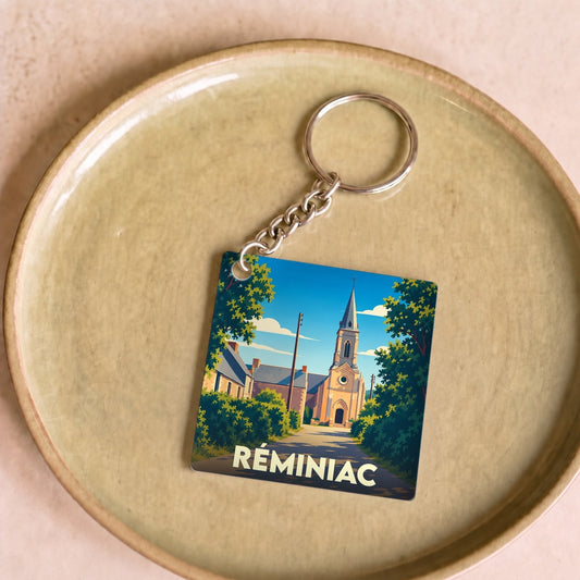 Porte-clés souvenir de la ville de Réminiac avec une illustration stylisée de son église.