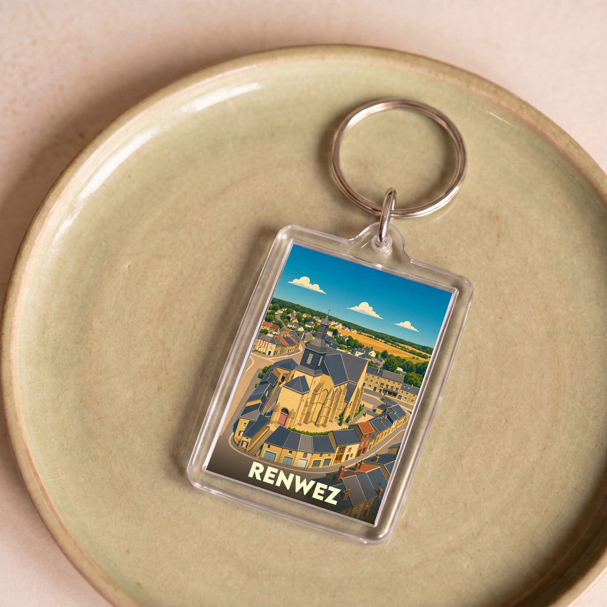 Porte-clés souvenir de la ville de Renwez avec une illustration stylisée de son église et de ses environs.