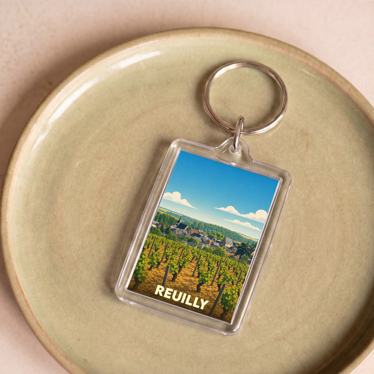 Porte-clés souvenir de la ville de Reuilly avec une illustration stylisée de ses vignobles.