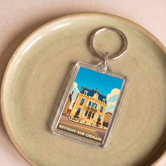 Porte-clés souvenir de la ville de Revigny-sur-Ornain avec une illustration stylisée de son hôtel de ville.
