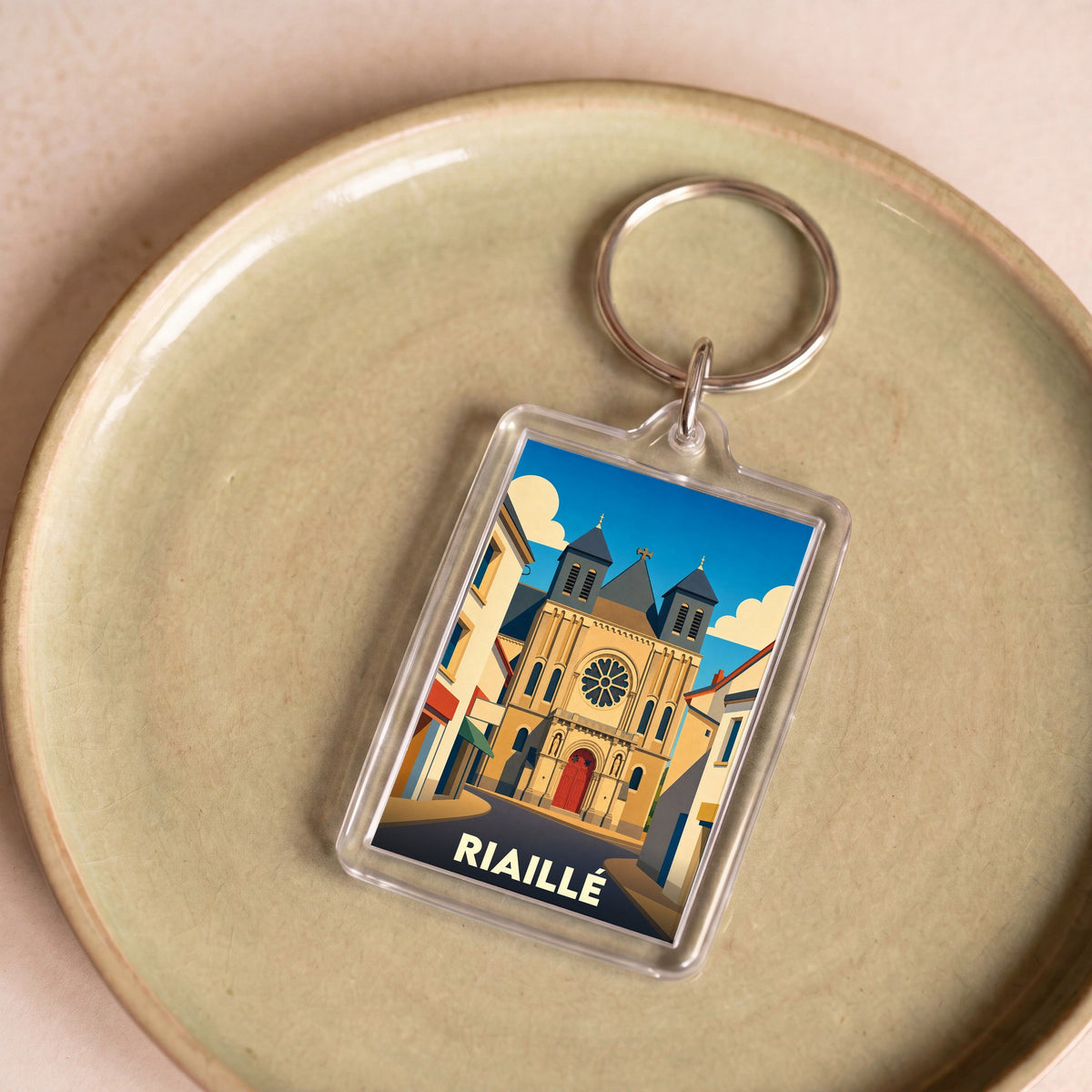 Porte-clés souvenir de la ville de Riaillé avec une illustration stylisée de son église.