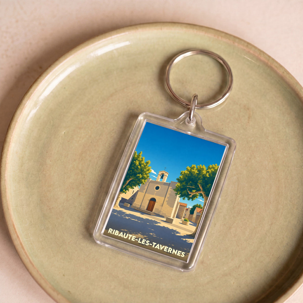 Porte-clés souvenir de la ville de Ribaute-les-Tavernes avec une illustration stylisée.