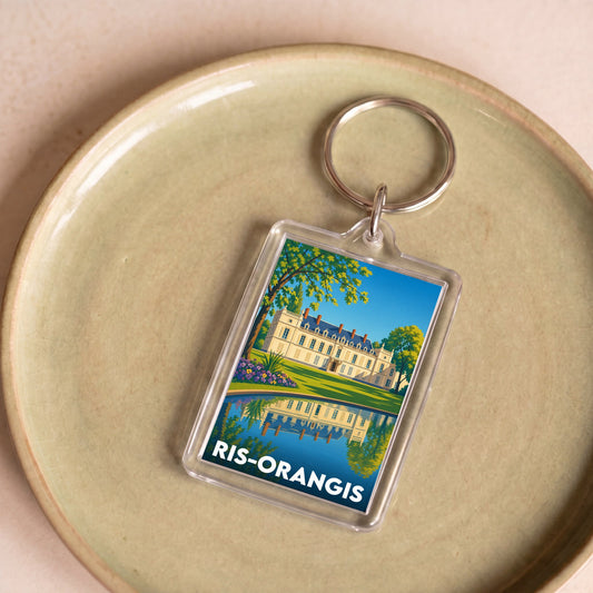 Porte-clés souvenir de la ville de Ris-Orangis avec une illustration stylisée.