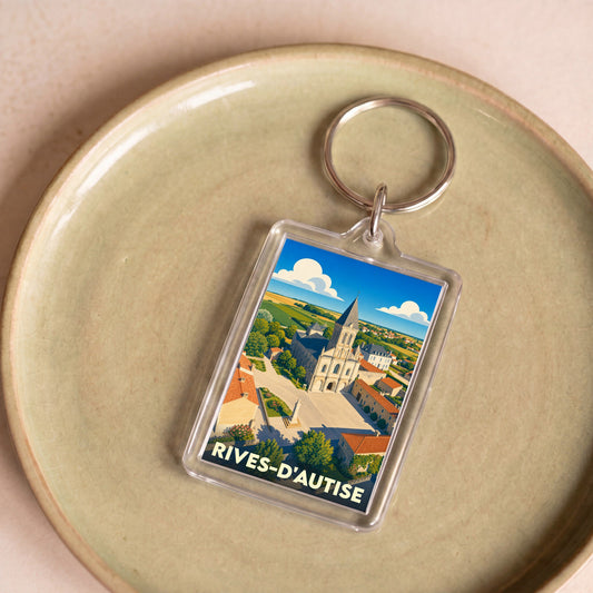 Porte-clés souvenir de la ville de Rives-d'Autise avec une illustration stylisée de son église et de sa place.