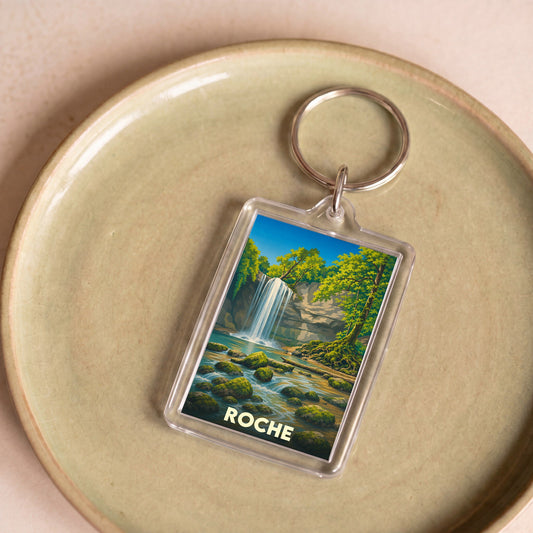 Porte-clés souvenir de la ville de Roche avec une illustration stylisée d'une cascade en forêt.