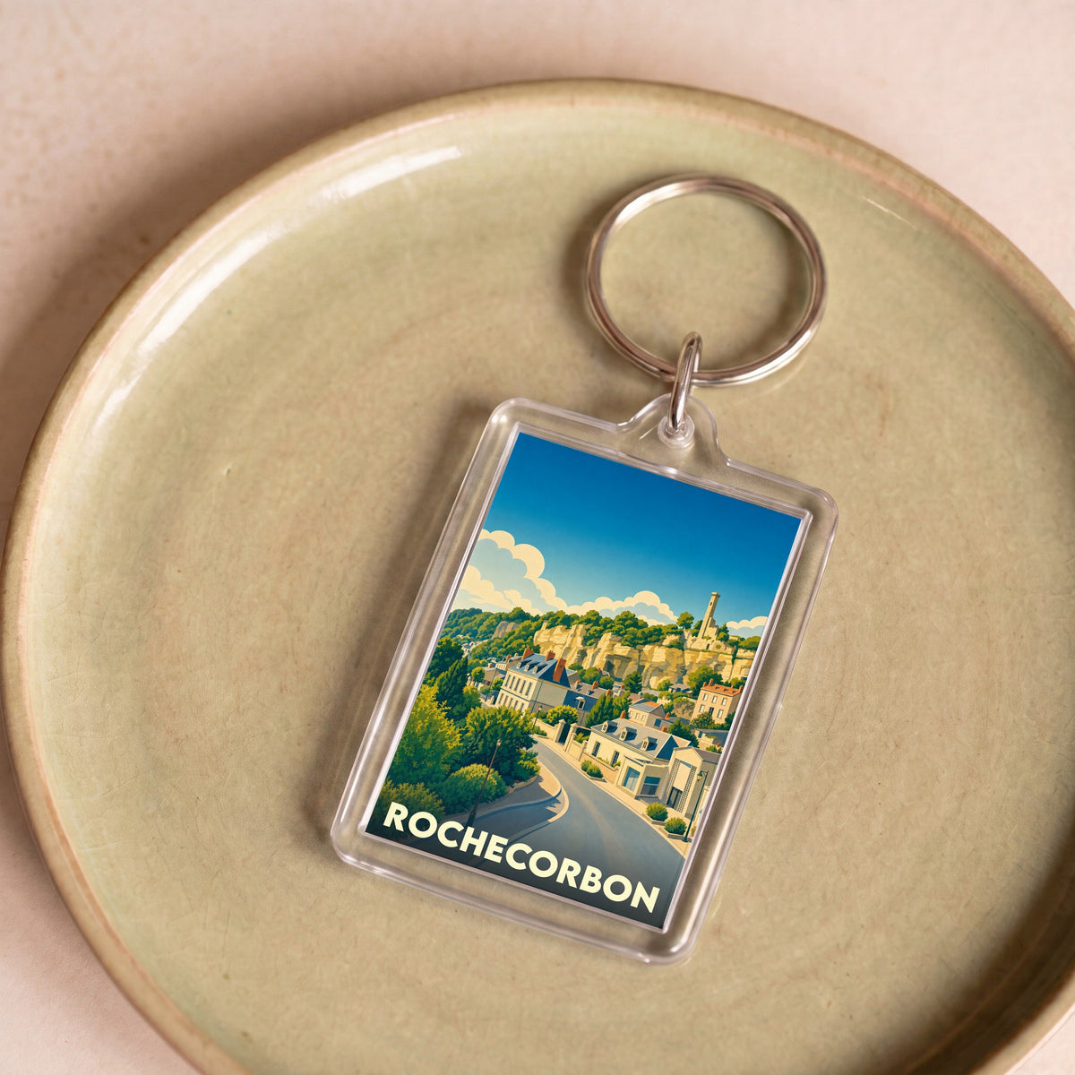 Porte-clés souvenir de la ville de Rochecorbon avec une illustration stylisée.