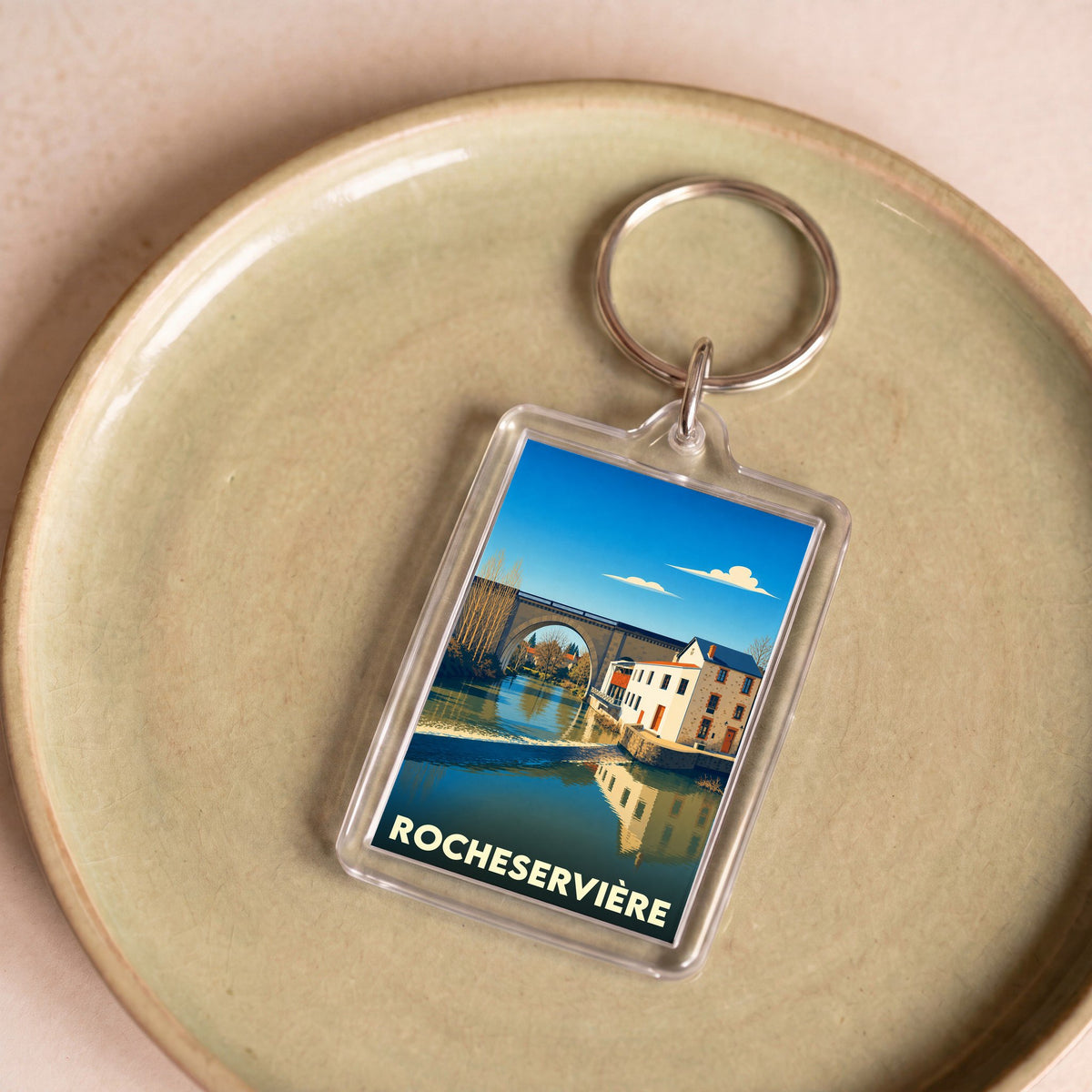 Porte-clés souvenir de la ville de Rocheservière avec une illustration stylisée.