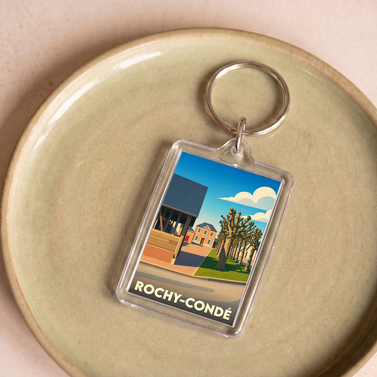 Porte-clés souvenir de la ville de Rochy-Condé avec une illustration stylisée.