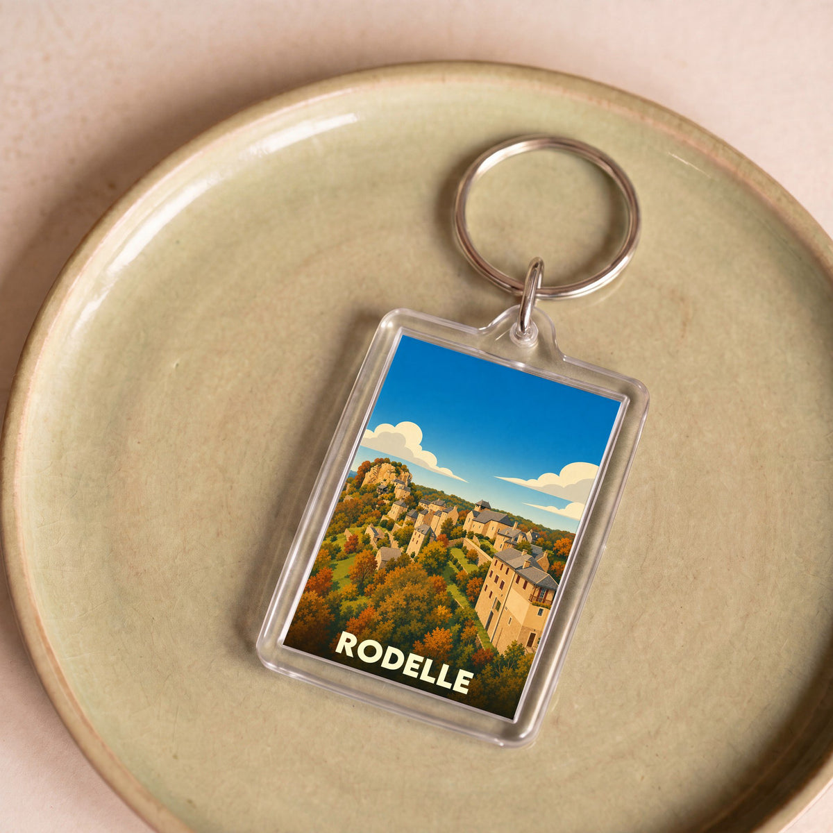 Porte-clés souvenir de la ville de Rodelle avec une illustration stylisée.