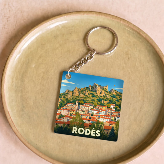 Porte-clés souvenir de la ville de Rodès avec une illustration stylisée de ses maisons et collines.