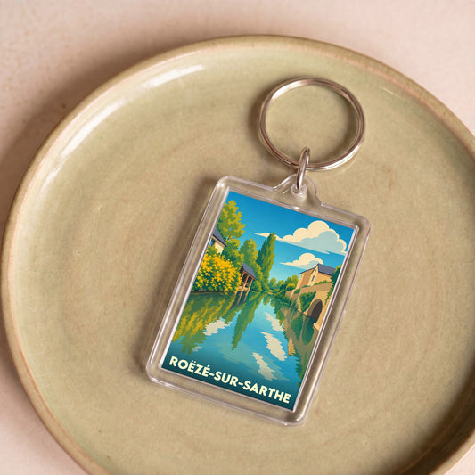 Porte-clés souvenir de la ville de Roëzé-sur-Sarthe avec une illustration stylisée des bords de la Sarthe.
