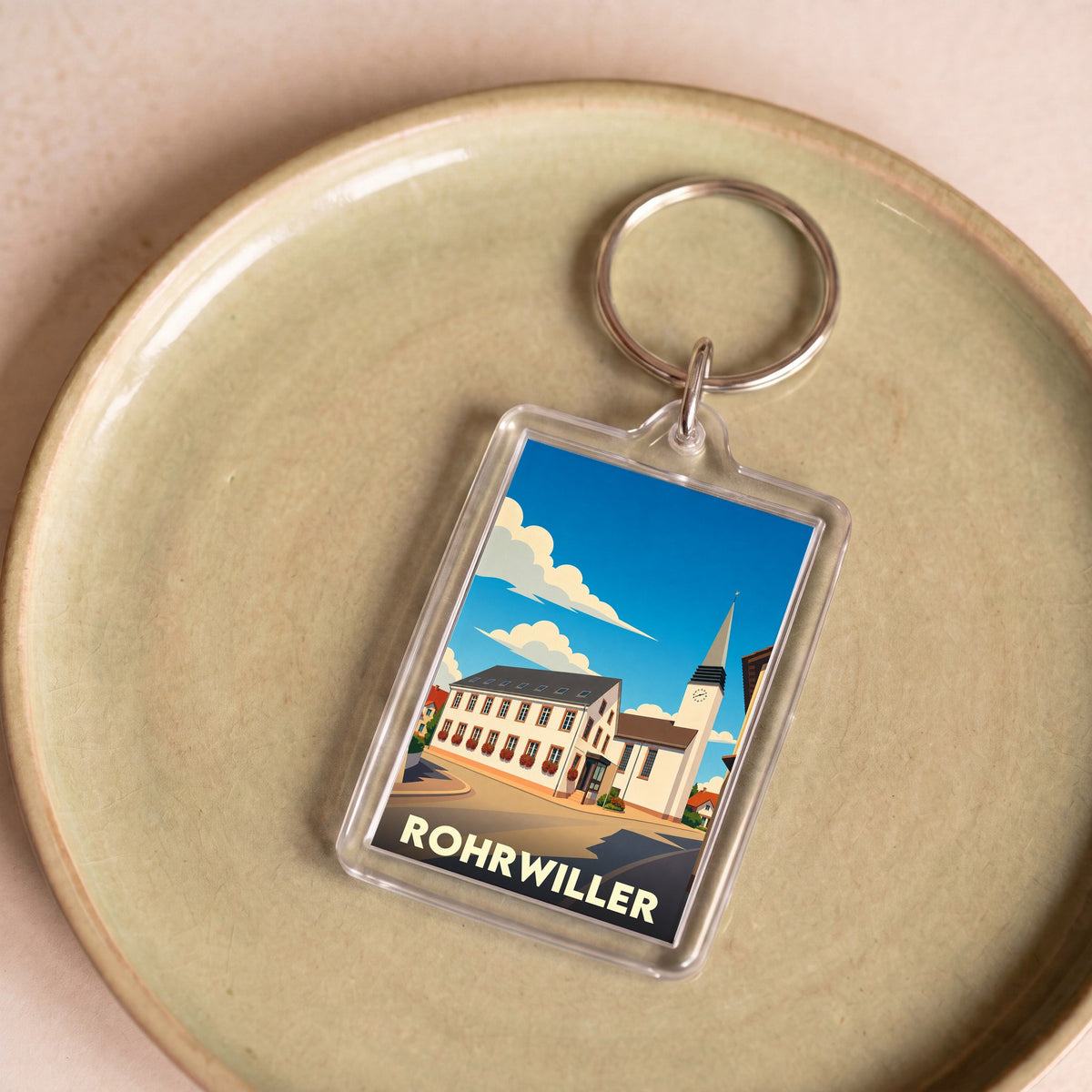Porte-clés souvenir de la ville de Rohrwiller avec une illustration stylisée de son église et de ses bâtiments.
