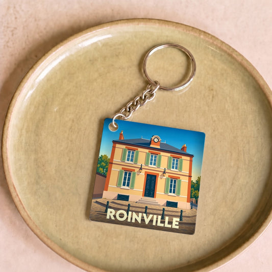 Porte-clés souvenir de la ville de Roinville avec une illustration stylisée de sa mairie.