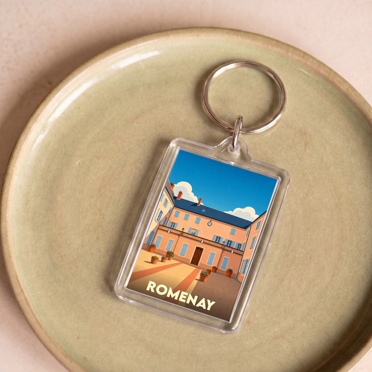 Porte-clés souvenir de la ville de Romenay avec une illustration stylisée de sa mairie.