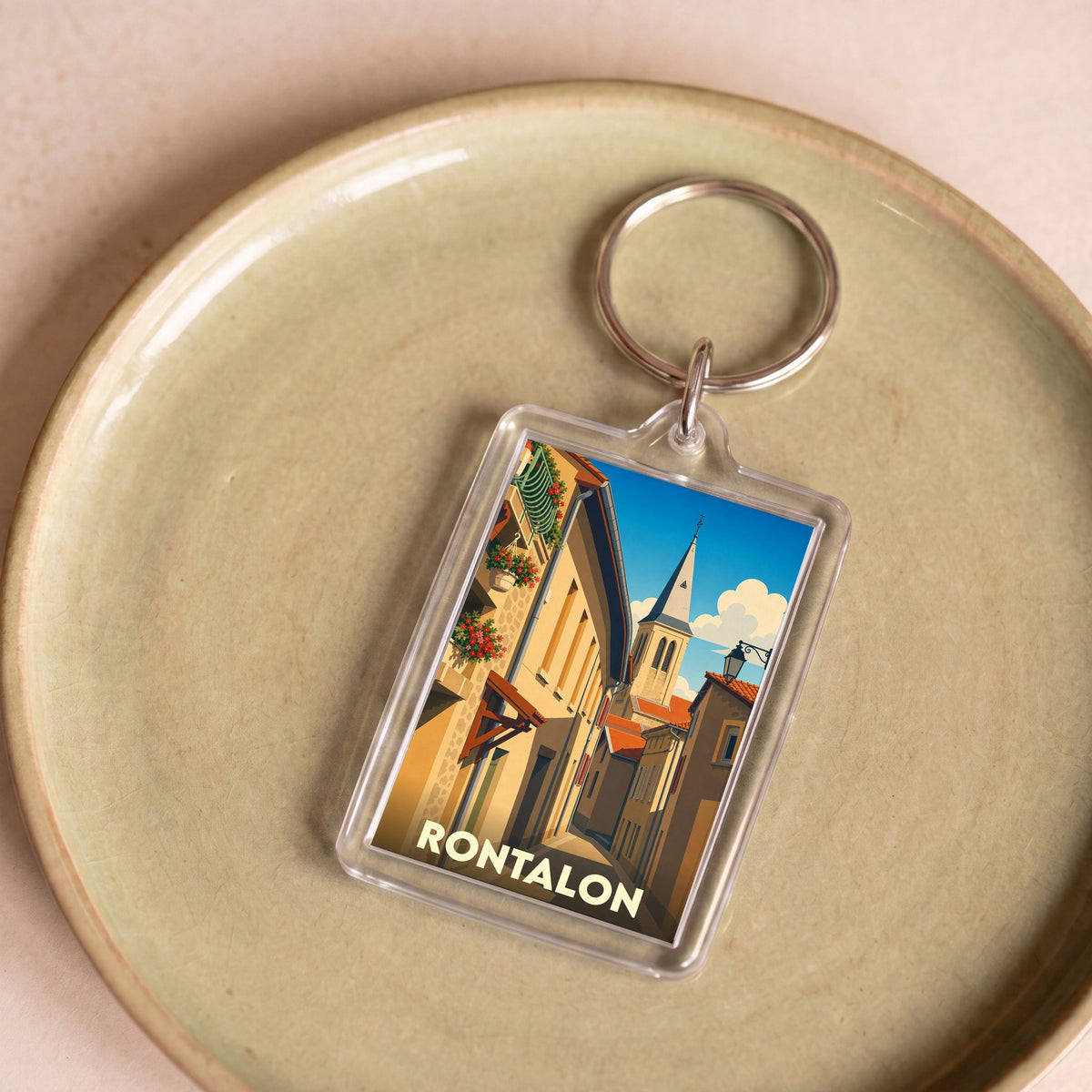 Porte-clés souvenir de la ville de Rontalon avec une illustration stylisée de ses rues et de son clocher.