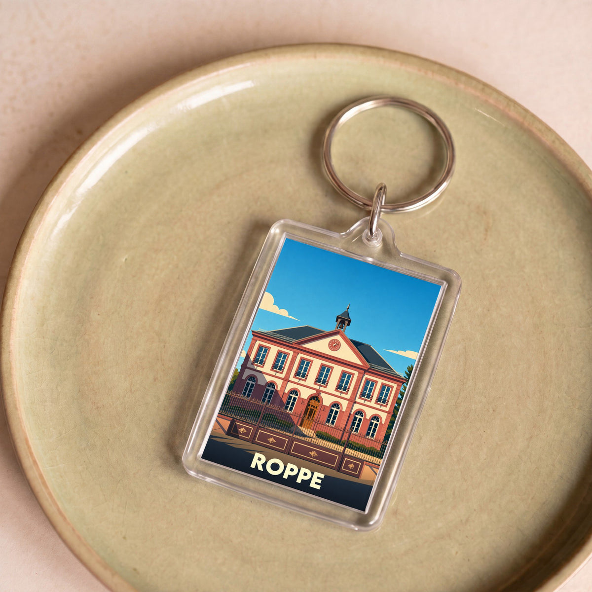 Porte-clés souvenir de la ville de Roppe avec une illustration stylisée de sa mairie.