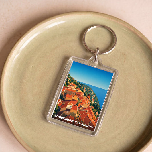 Porte-clés souvenir de la ville de Roquebrune-Cap-Martin avec une illustration stylisée.