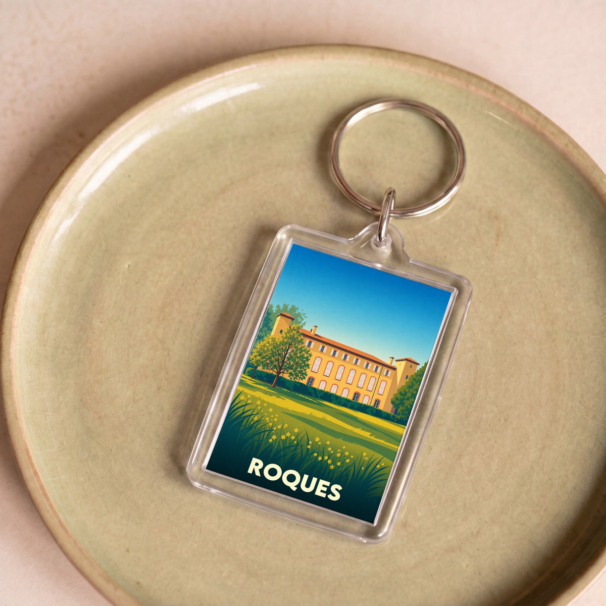 Porte-clés souvenir de la ville de Roques avec une illustration stylisée d'un château.