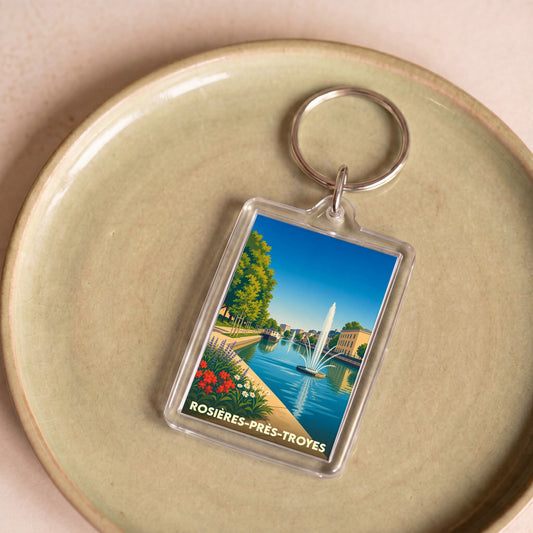 Porte-clés souvenir de la ville de Rosières-près-Troyes avec une illustration stylisée d'un plan d'eau et d'un jet d'eau.