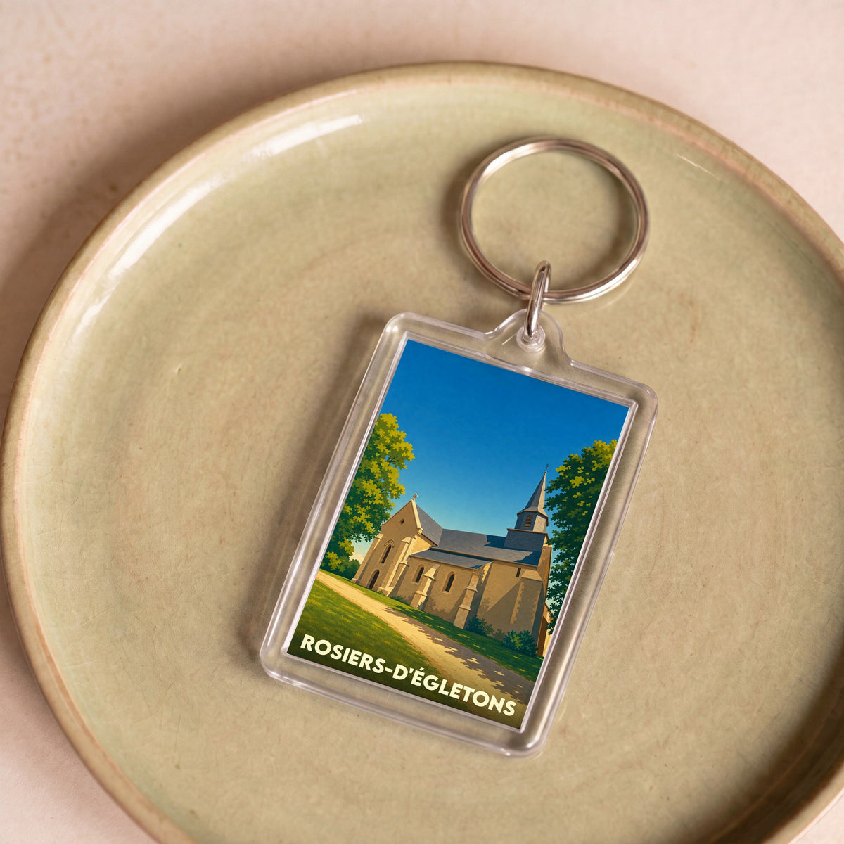 Porte-clés souvenir de la ville de Rosiers-d'Égletons avec une illustration stylisée de son église.
