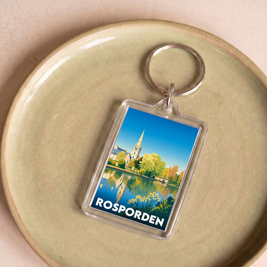 Porte-clés souvenir de la ville de Rosporden avec une illustration stylisée d'un paysage urbain au bord de l'eau.