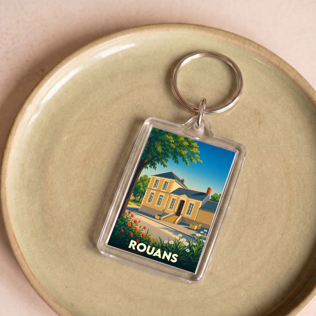 Porte-clés souvenir de la ville de Rouans avec une illustration stylisée d'une maison de maître.
