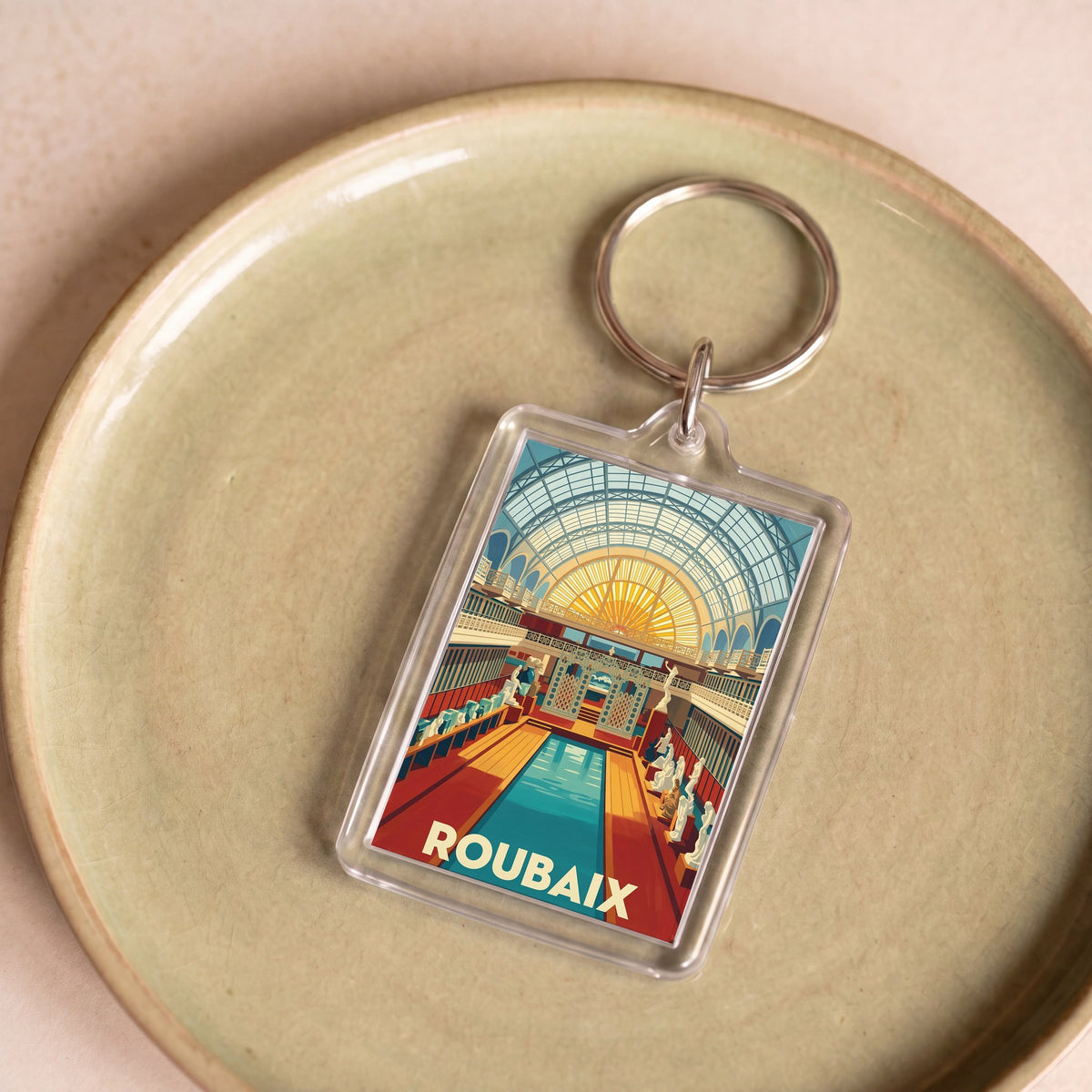 Porte-clés souvenir de la ville de Roubaix avec une illustration stylisée.