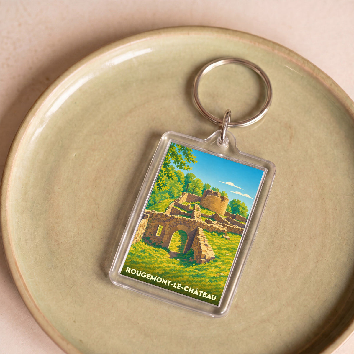 Porte-clés souvenir de Rougemont-le-Château avec une illustration stylisée des ruines de son château.