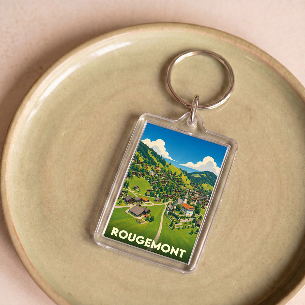 Porte-clés souvenir de la ville de Rougemont avec une illustration stylisée du village de montagne.
