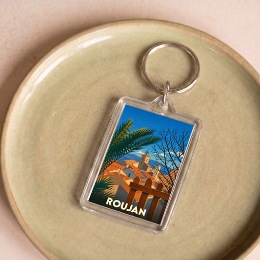 Porte-clés souvenir de la ville de Roujan avec une illustration stylisée.