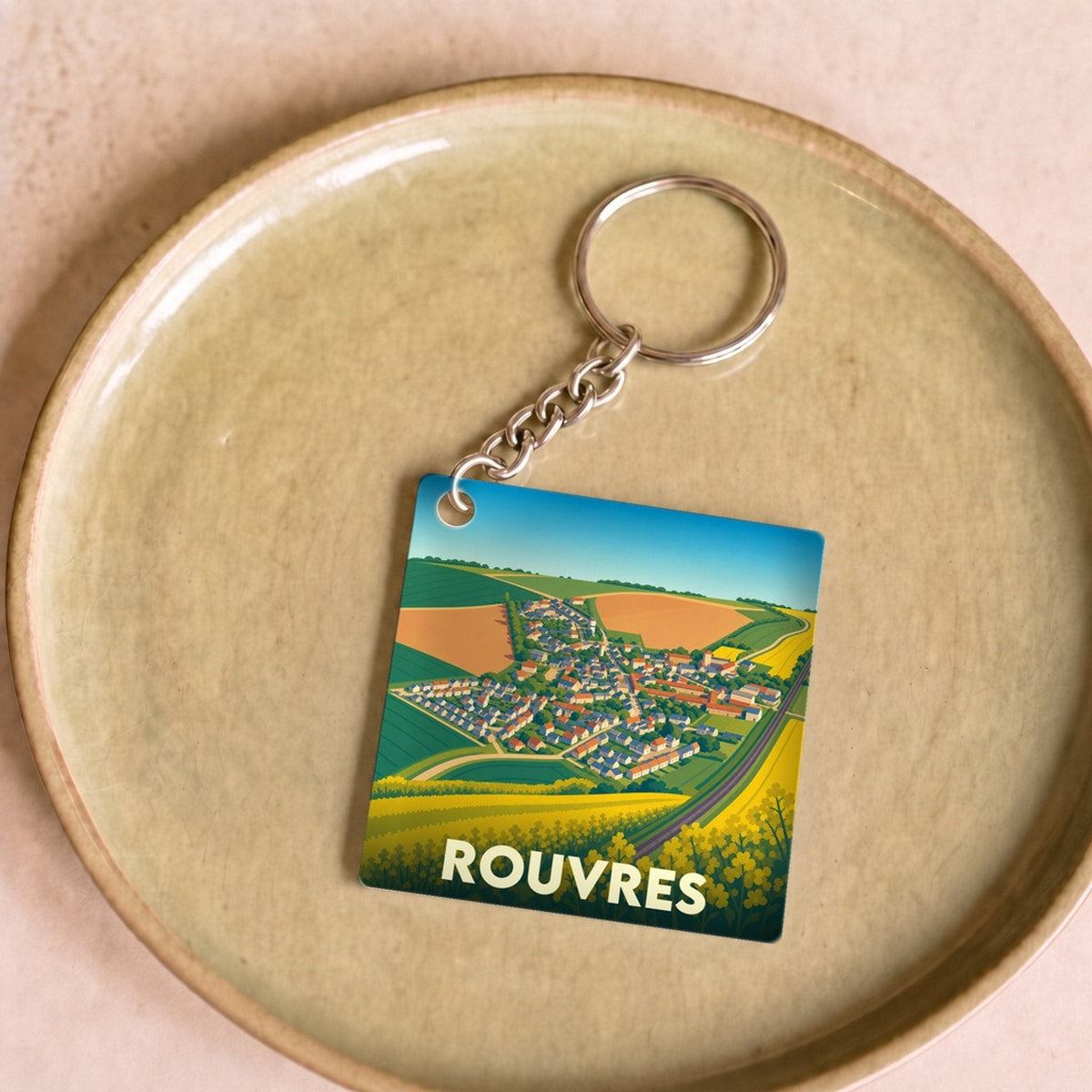 Porte-clés souvenir de la ville de Rouvres avec une illustration stylisée.