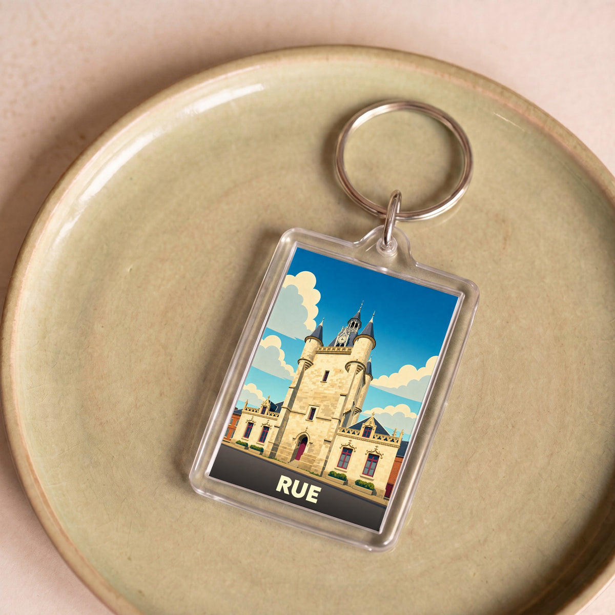 Porte-clés souvenir de la ville de Rue avec une illustration stylisée de son beffroi.
