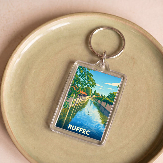 Porte-clés souvenir de la ville de Ruffec avec une illustration stylisée d'un canal bordé de verdure.