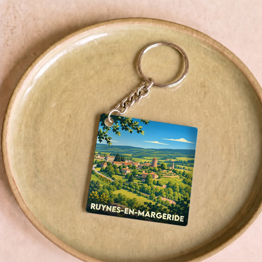 Porte-clés souvenir de la ville de Ruynes-en-Margeride avec une illustration paysagère stylisée.