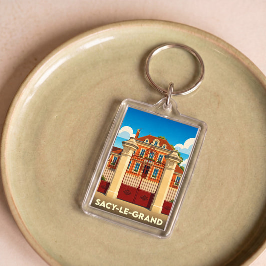 Porte-clés souvenir de la ville de Sacy-le-Grand avec une illustration stylisée d'un domaine historique.