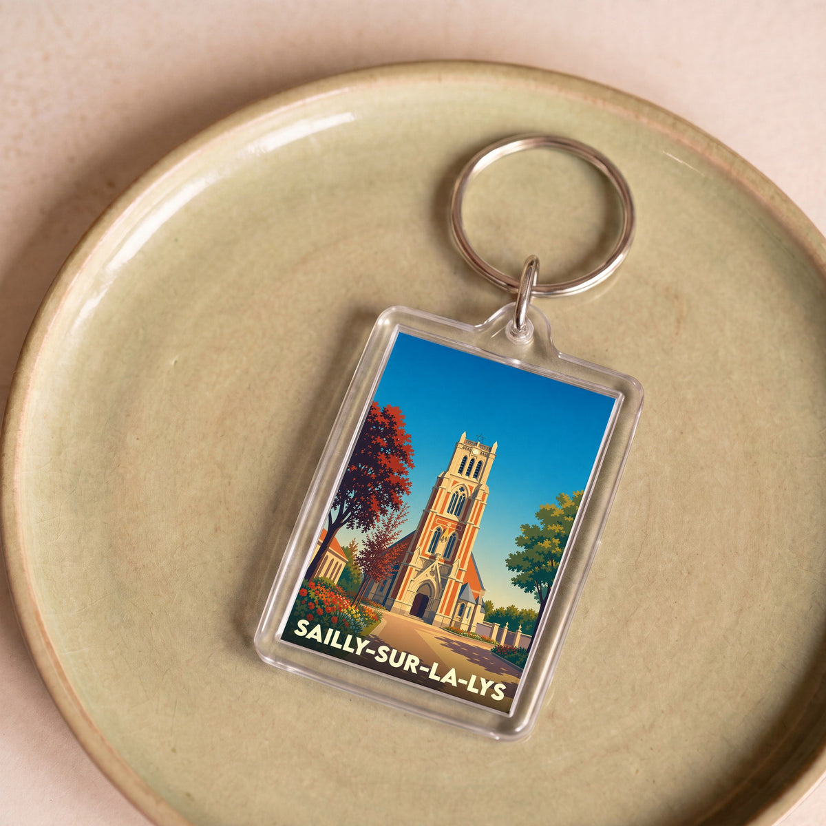 Porte-clés souvenir de la ville de Sailly-sur-la-Lys avec une illustration stylisée de son église.