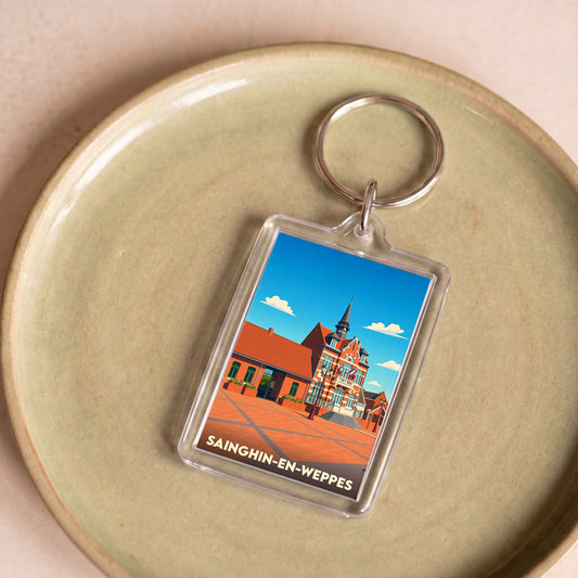 Porte-clés souvenir de la ville de Sainghin-en-Weppes avec une illustration stylisée de son hôtel de ville.
