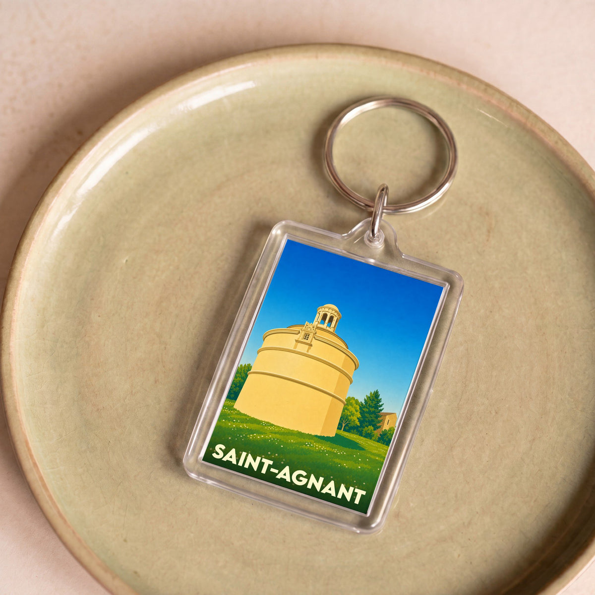 Porte-clés souvenir de la ville de Saint-Agnant avec une illustration stylisée.