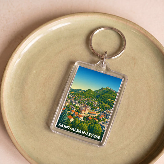 Porte-clés souvenir de la ville de Saint-Alban-Leysse avec une illustration stylisée d'un paysage montagneux.